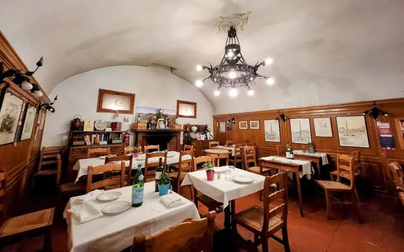Testaccio restaurant in Rome, Italy with rustic wooden tables and chandelier.