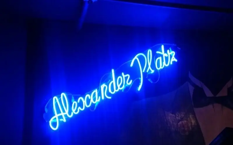 Alexanderplatz neon sign glowing in blue.