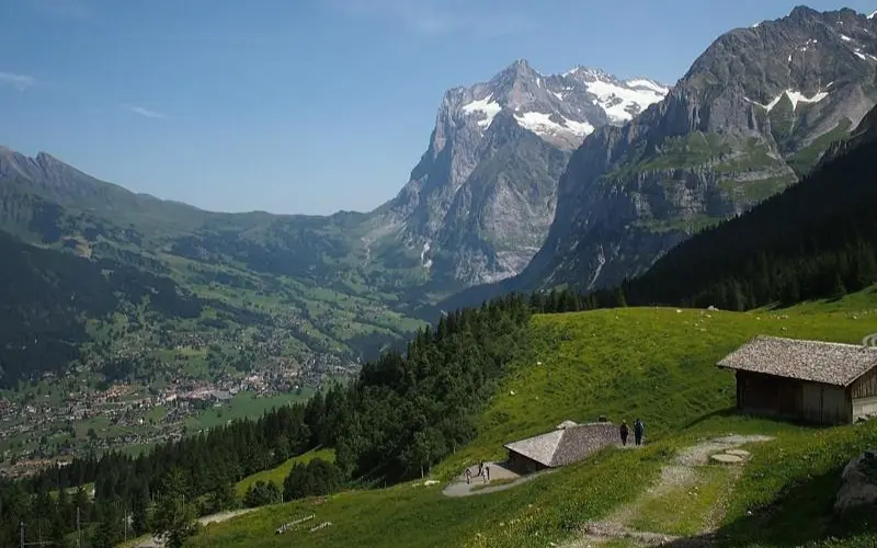 Eiger, Grindelwald features green valleys and wooden huts beneath the towering Eiger mountain.