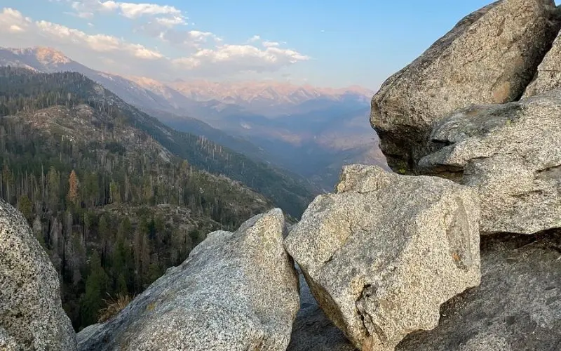 A rocky viewpoint overlooking forested mountains from Moro Rock.
