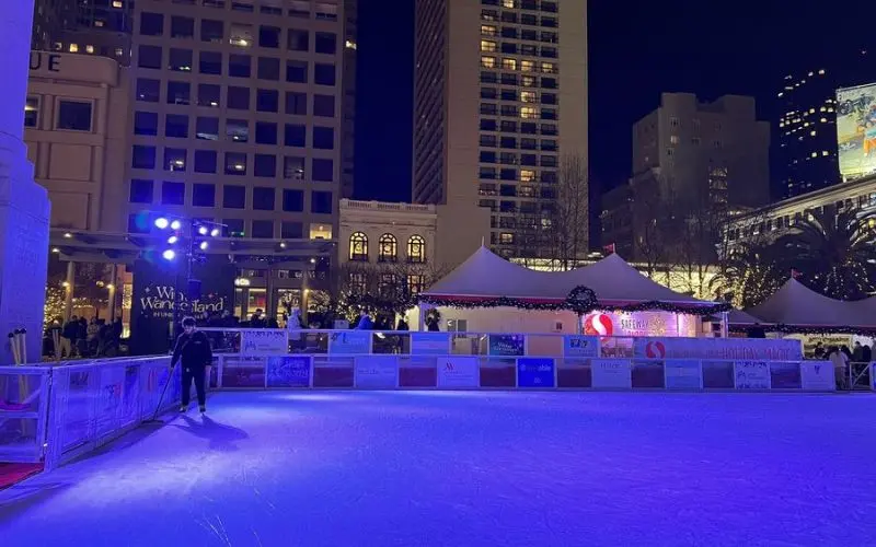 Outdoor ice skating rink at Union Square lit up at night.