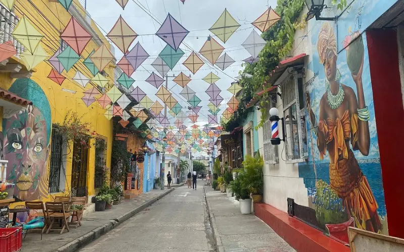 Colorful murals and hanging decorations on a street in Getsemaní.