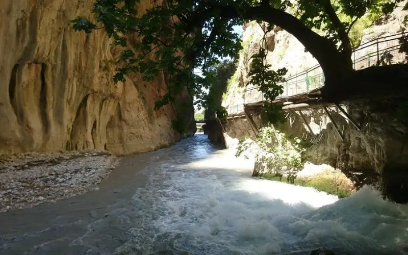 Flowing river between steep cliffs at Saklikent Gorge.