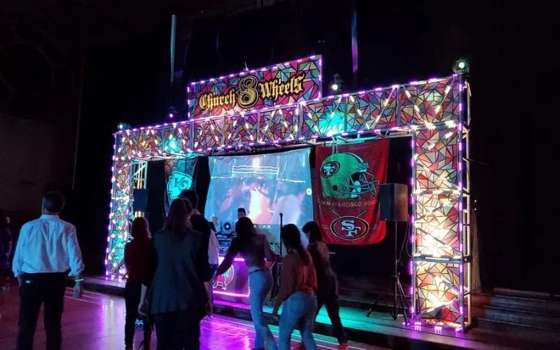 People roller skating under neon lights at Church of 8 Wheels.