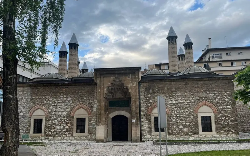 Stone exterior with domes and minarets at Gazi Husrev-beg Mosque.