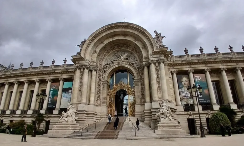 The ornate front entrance of Musée du Petit Palais with decorative arches and statues.