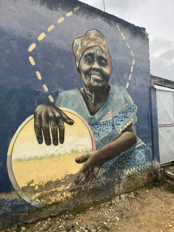Wall mural of a woman with a drum in Palenque.