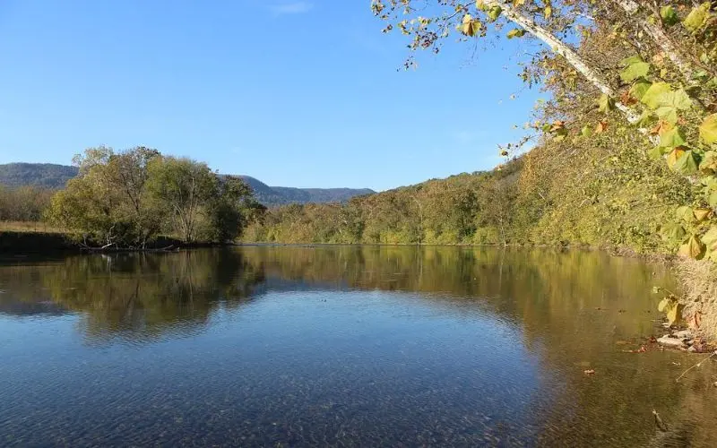 Calm waters of the Shenandoah River surrounded by forested hills.
