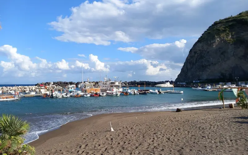 Fishing boats docked by the sandy Spiaggia dei Pescatori.