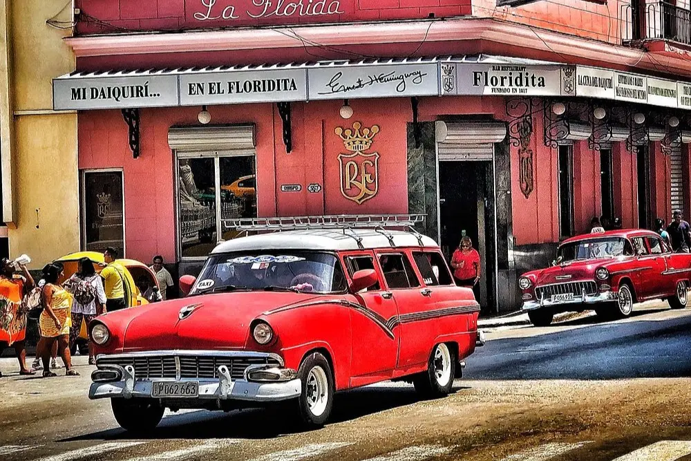 Classic red cars in front of El Floridita bar in Old Havana.