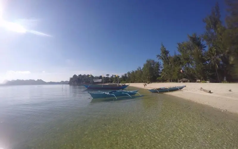 Wooden boats sit along the shore of Dampalitan Island.
