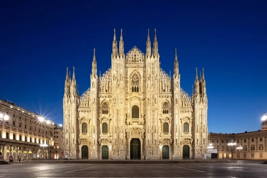 The illuminated Duomo di Milano cathedral at night.