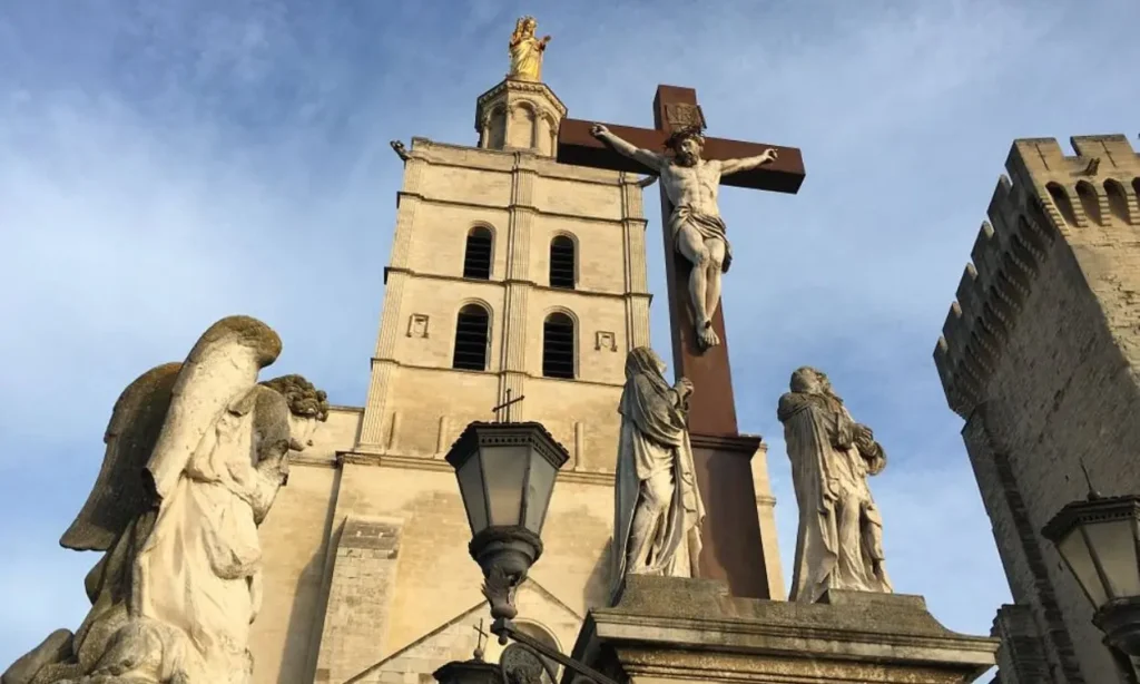 The crucifix and statues in front of Avignon Cathedral’s bell tower.