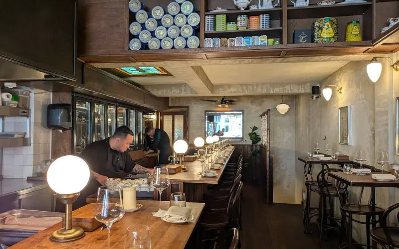 Cozy interior of Bistro de la Mer with a long wooden bar.