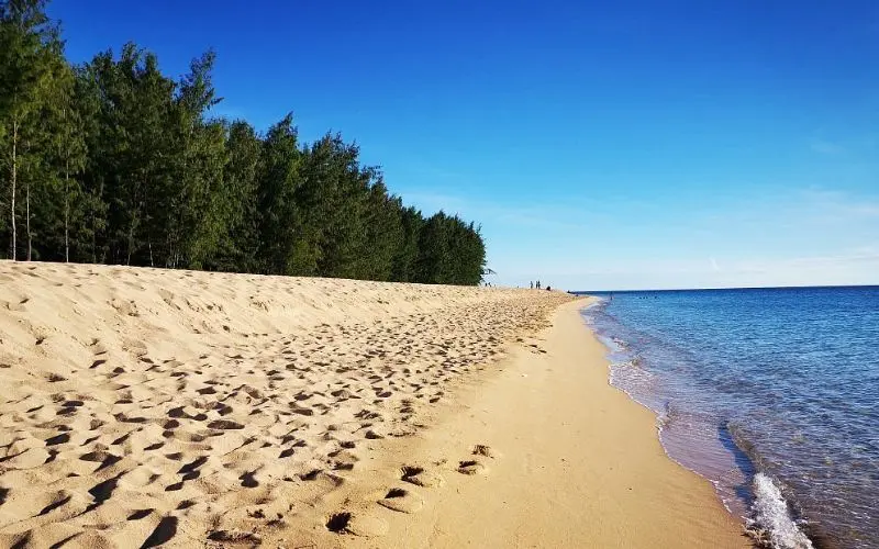 Golden sand and calm blue water line the coast of Jomalig Island.