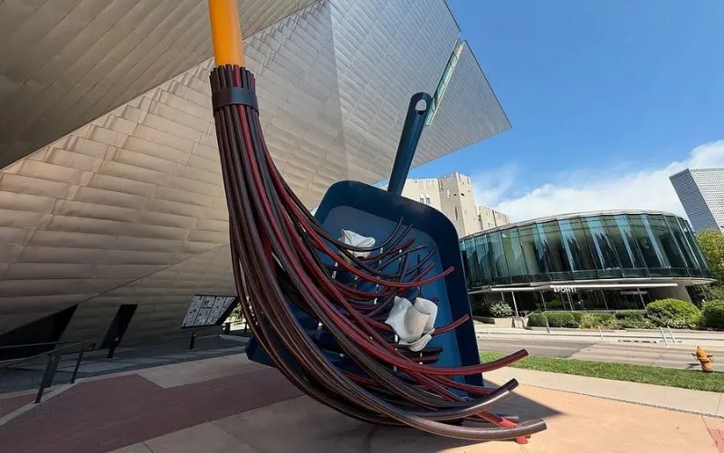 A giant broom and dustpan sculpture stands outside the Denver Art Museum.