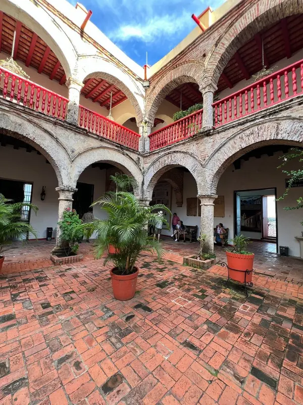 Brick courtyard with arches and red railings at La Popa Convent.