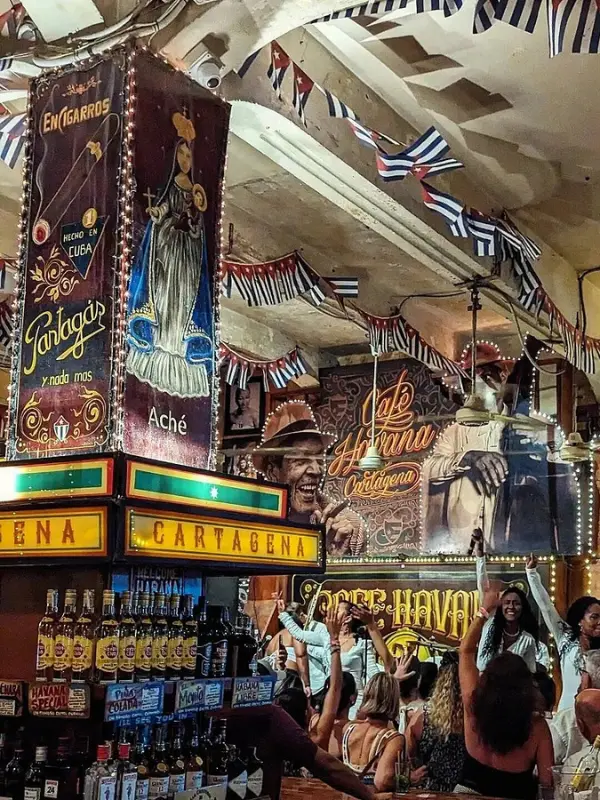 Colorful interior with music posters and dancing crowd at Café Havana.