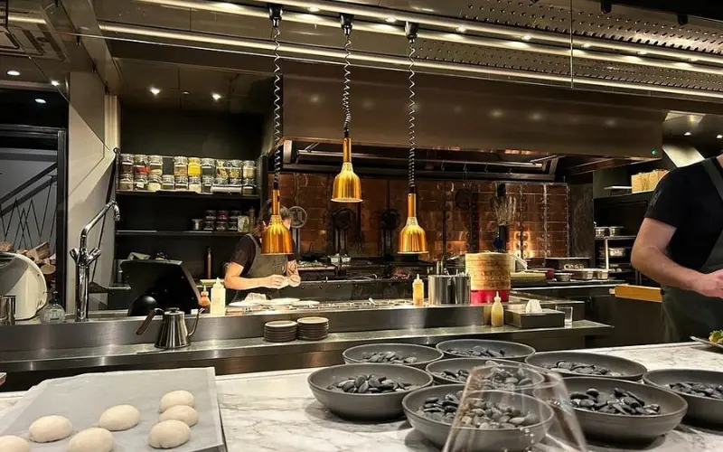 Open kitchen view at Restaurant Wils with chefs preparing food.