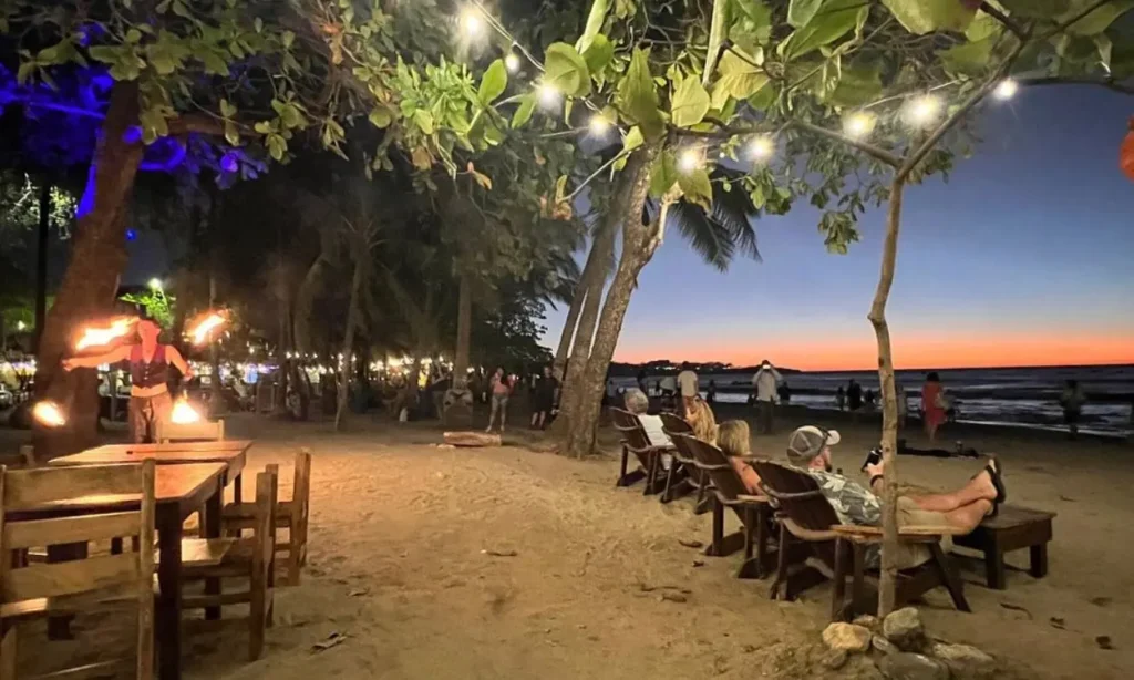 A fire performer entertaining visitors under string lights at Tamarindo Night Market.
