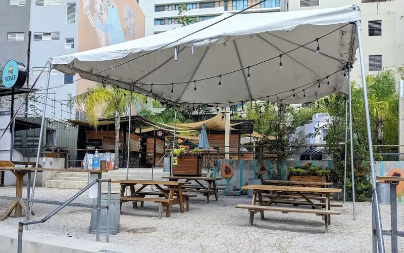 Outdoor food court with picnic tables at Lote 23.