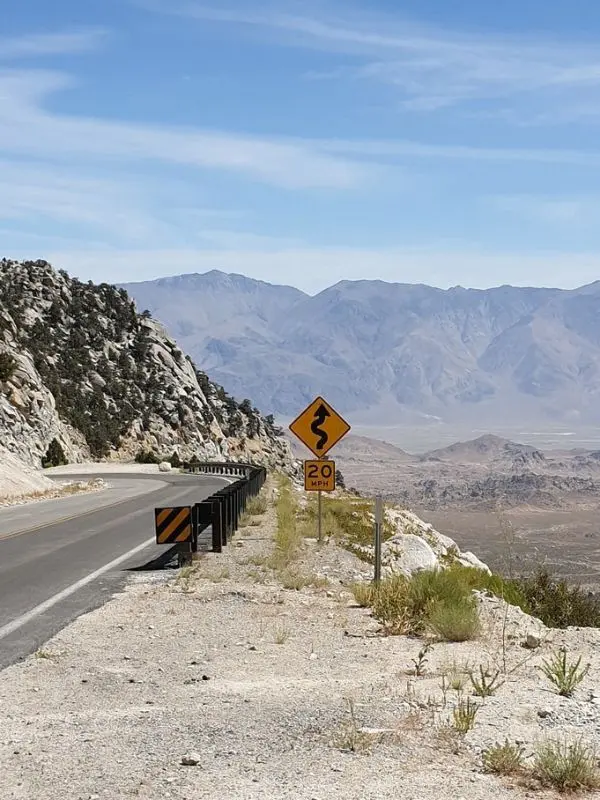 A winding mountain road with views of Mount Whitney.