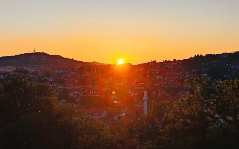 A sunset view over Sarajevo’s red-roofed houses and hills, with the fortress providing a panoramic vantage point.