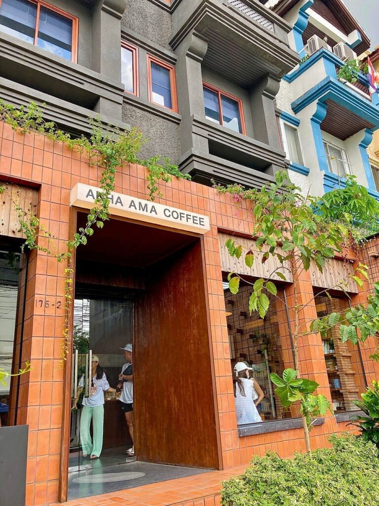 Akha Ama Coffee Prasingh with a modern brick exterior and greenery around the entrance.