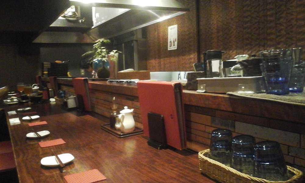 Interior of Anzukko with a cozy counter seating setup and open griddle kitchen.