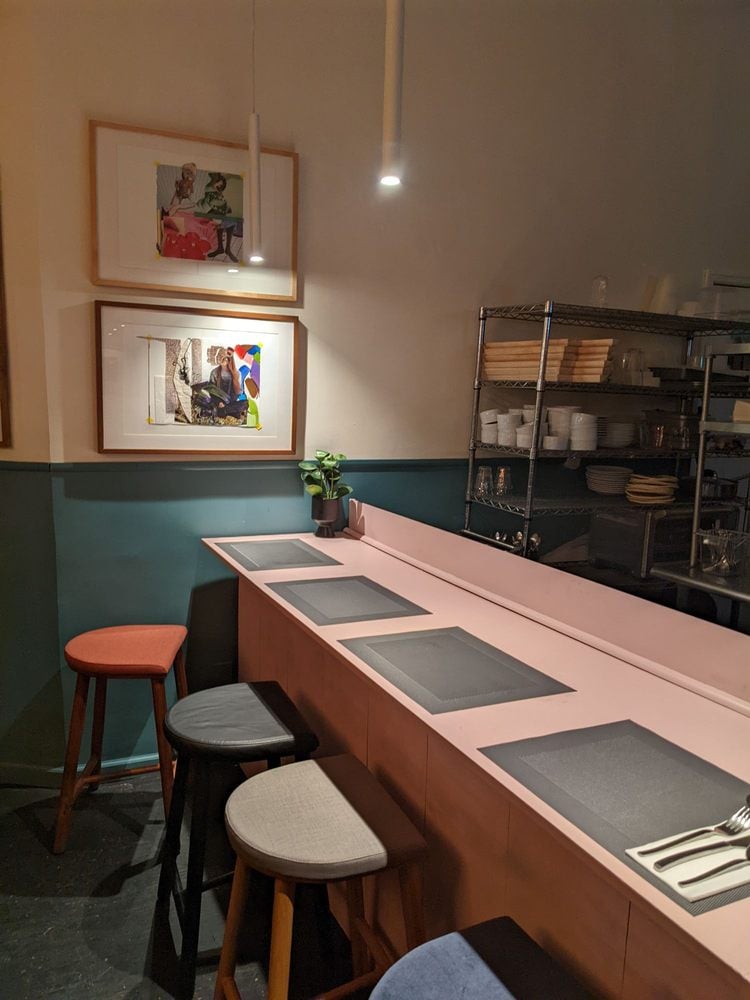 Cozy counter seating inside Dept of Culture with colorful art on the walls.