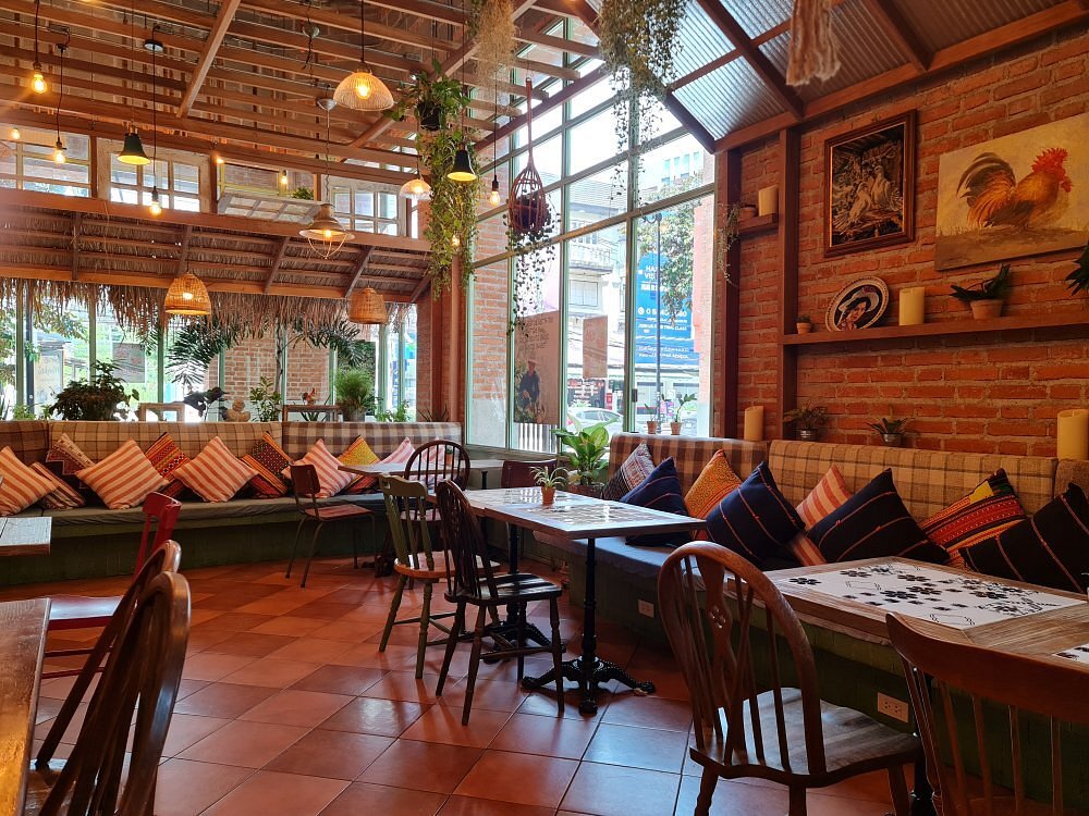 Ginger Farm Kitchen with cozy seating, colorful pillows, and large windows.