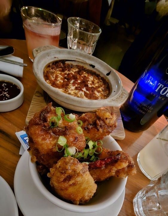 Table at Haenyeo featuring Korean fried chicken and cheesy dip.
