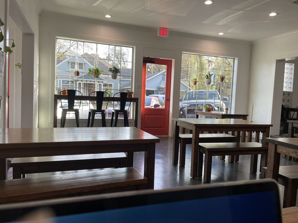Bright and cozy interior of Harvest on 25th with wooden tables.
