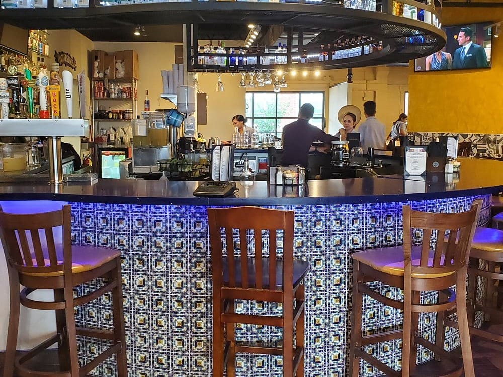 Vibrant bar area at Hecho En Waco with colorful tile design.