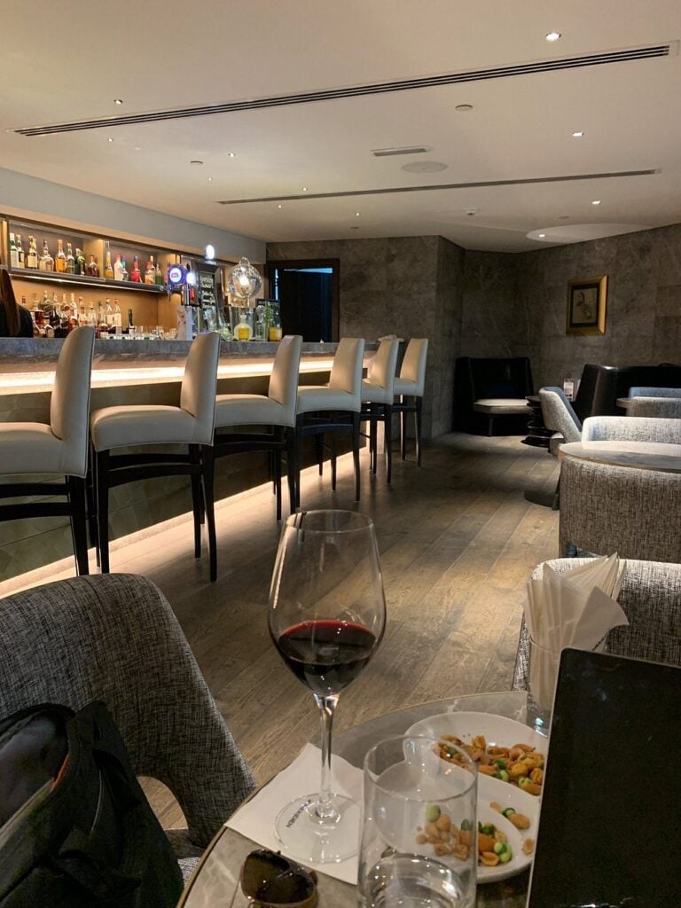 Latitude 25 lounge with a modern bar, ambient lighting, and wine served at a cozy table.
