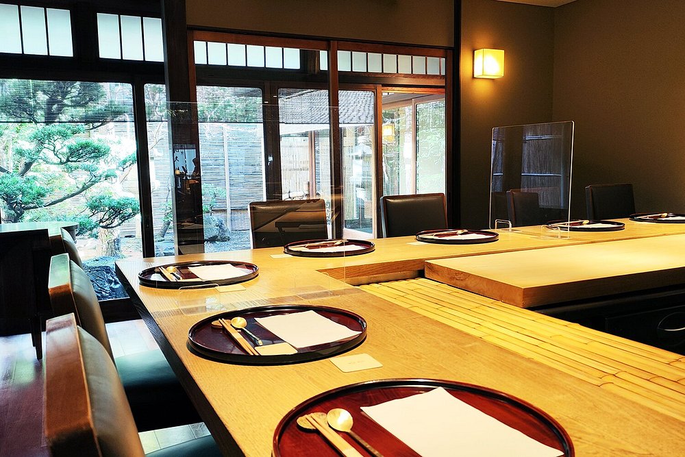 Refined counter seating at Muromachi Wakuden with garden views and traditional Japanese decor.