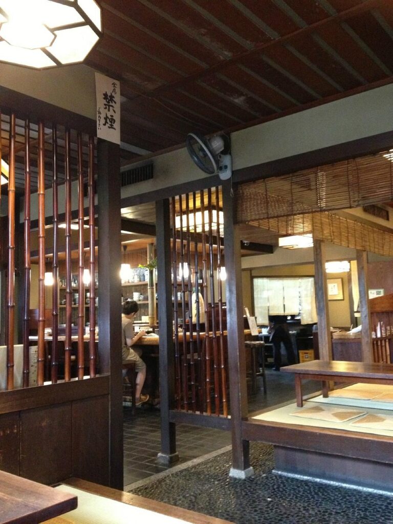 Traditional wooden interior of Omen Ginkaku-ji with tatami seating and bamboo accents.