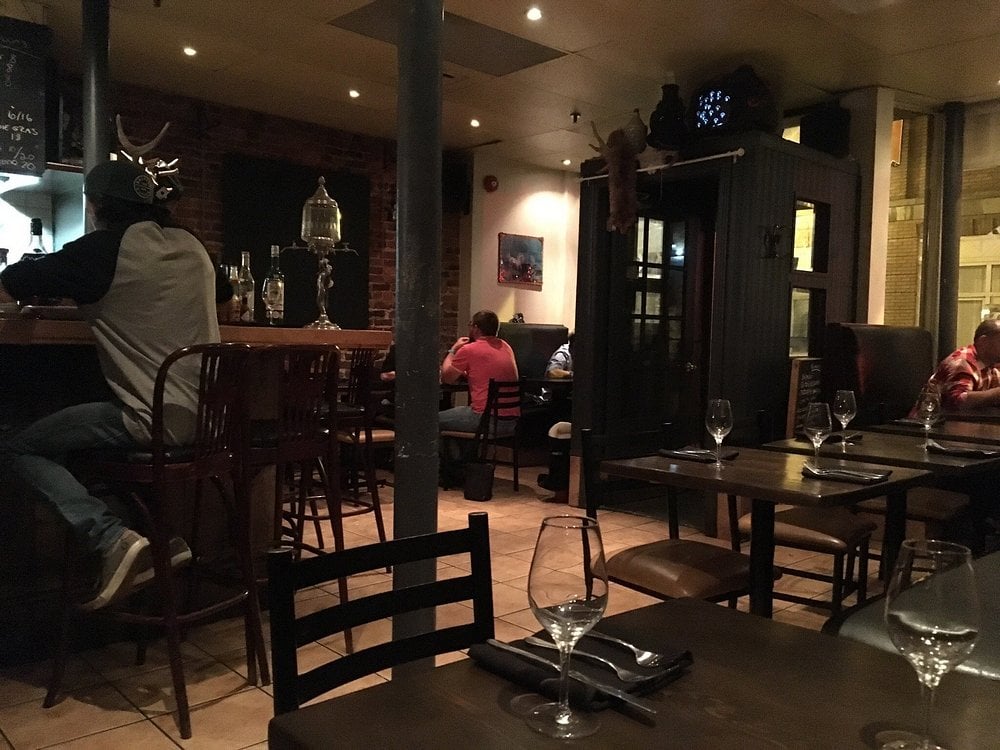 Interior of Patente et Machin, a cozy, dimly-lit bistro with rustic decor.