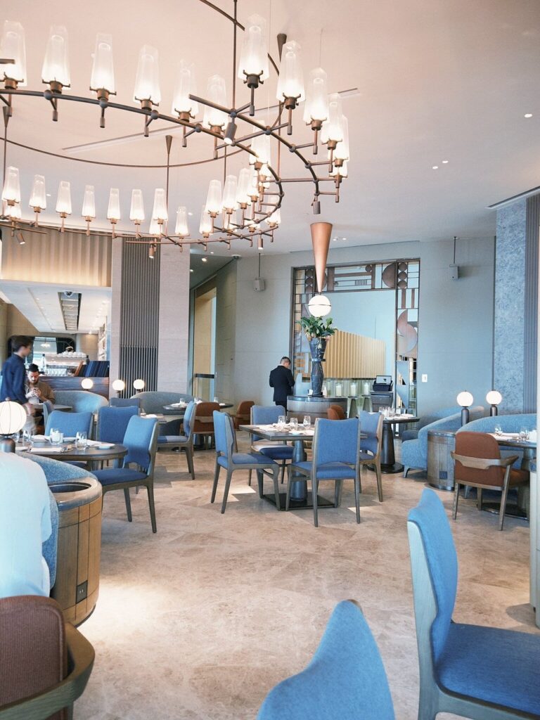Bright and stylish dining room at Salisterra with blue chairs and modern lighting.