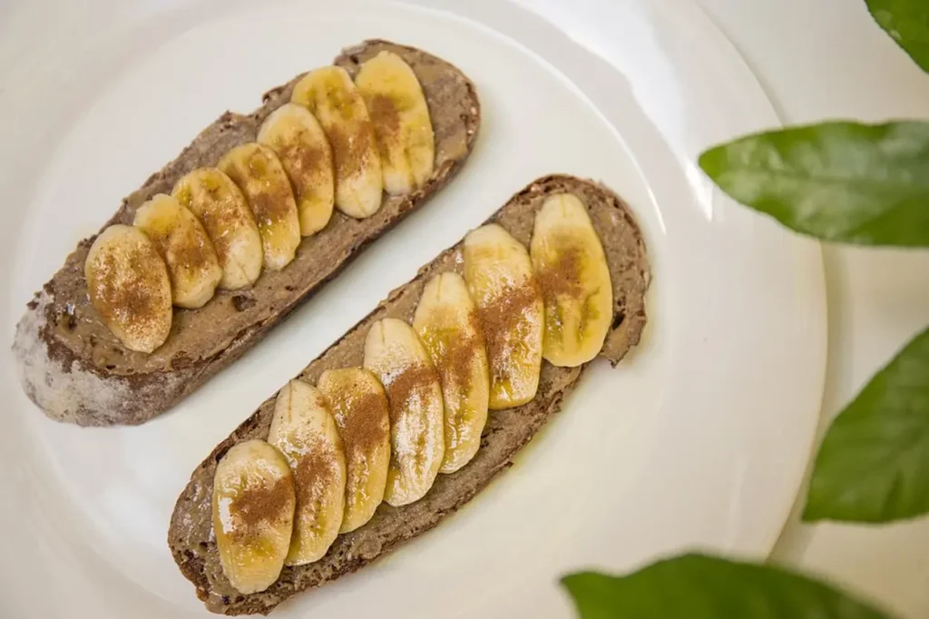 Homemade dark rye bread smothered in Tahini and topped with banana, honey and cinnamon