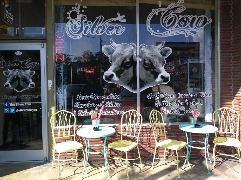 Front of Silver Cow with cow graphics and colorful outdoor seating.