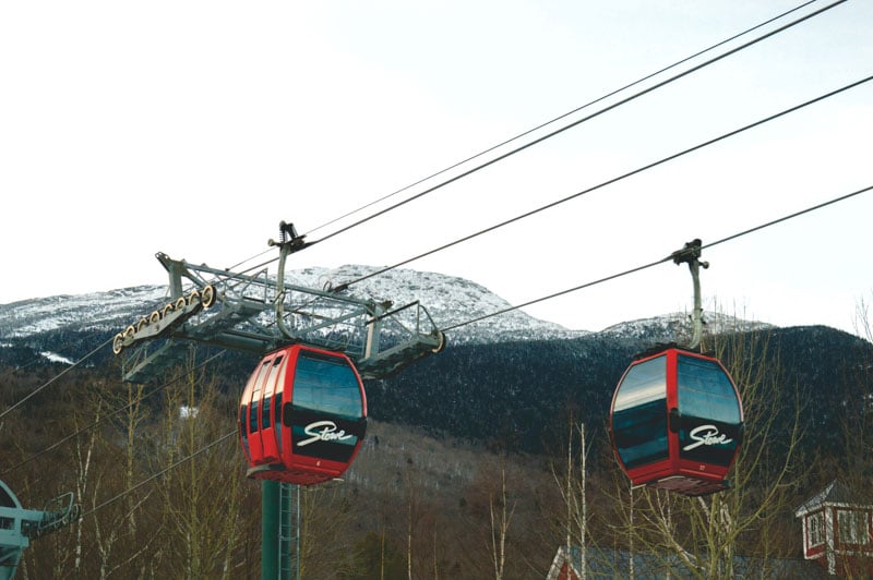Ski lift at Stowe Mountain Resort against snow-covered slopes and scenic mountain views.