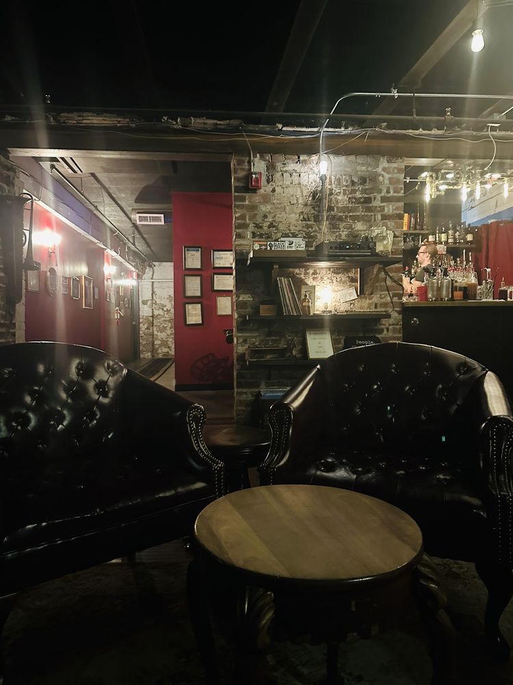 Dimly lit speakeasy-style lounge at Swordfish Tom's with leather seating.
