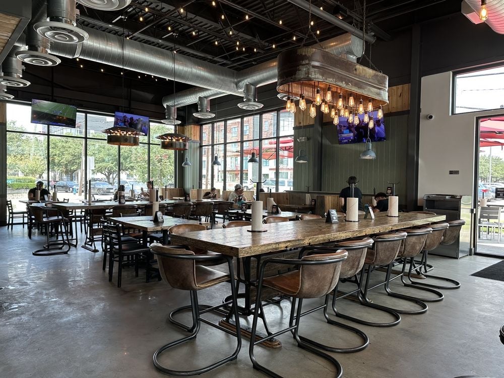 The Cookshack dining area with rustic tables, leather chairs, and large windows.