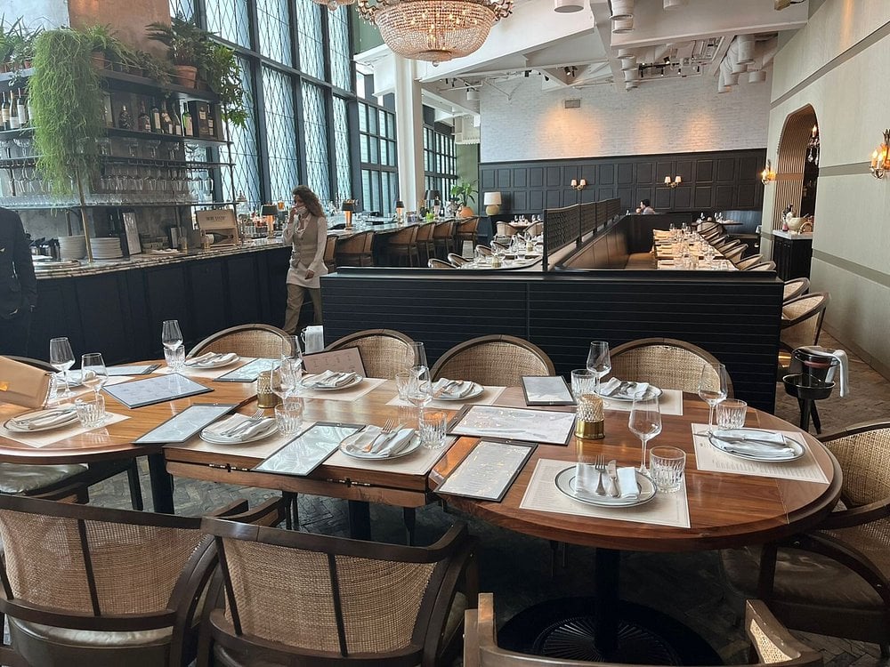 The Maine Land Brasserie dining area with elegant table settings and a stylish bar backdrop.