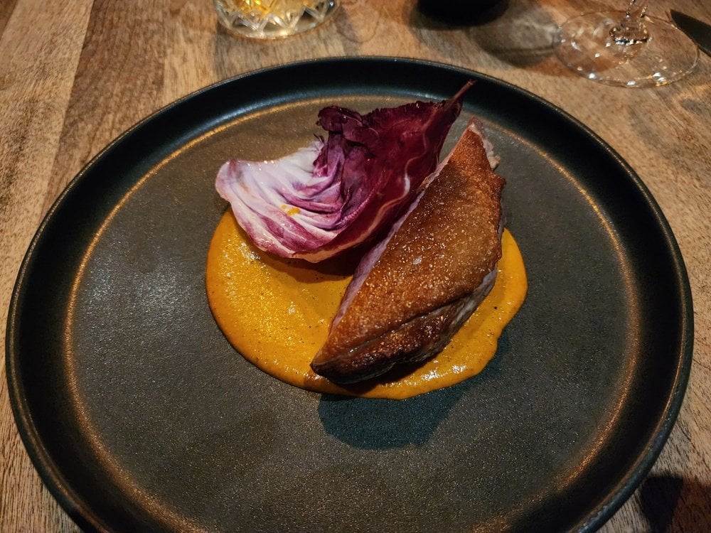 A plated dish at Verre Pickl’, featuring creative presentation on a modern black plate.