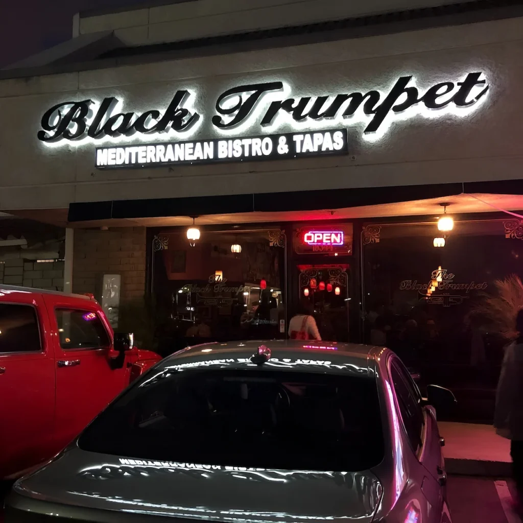 The exterior storefront of Black Trumpet Mediterranean Bistro & Tapas at night