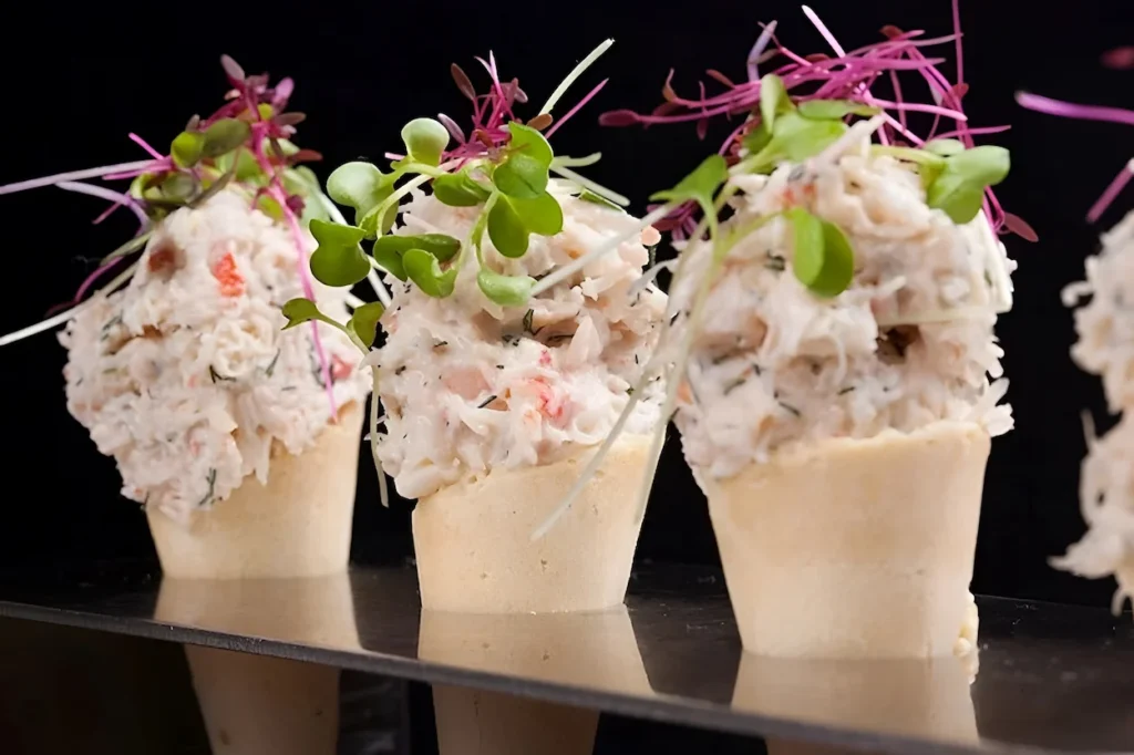 Crab salad served in savory pastry cones, garnished with fresh microgreens.