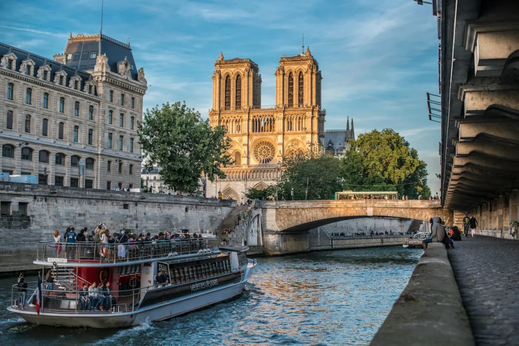 Cruise boat on the Seine River passing Notre-Dame Cathedral in Paris