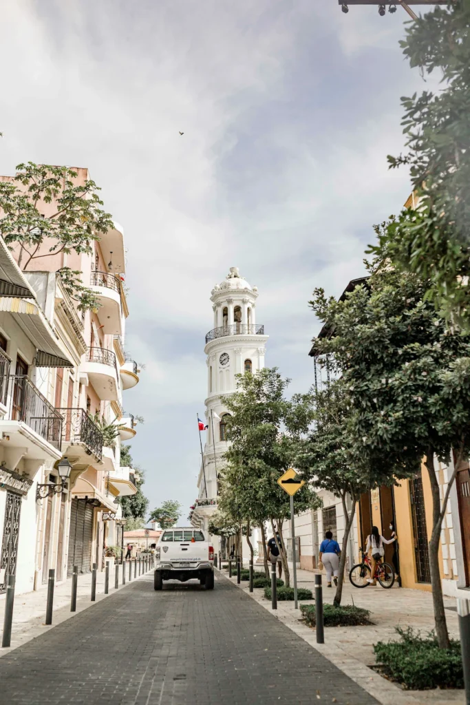 Palacio Consistorial clock tower rising above a street lined with historic colonial buildings in Santo Domingo